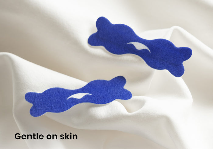 Two blue Manta nasal strips featuring the white Manta Sleep logo, displayed on textured white fabric. Text overlay: "Gentle on skin".